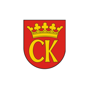 Herb z koroną i literami "CK" na czerwonym tle. Symbol organizacji.
